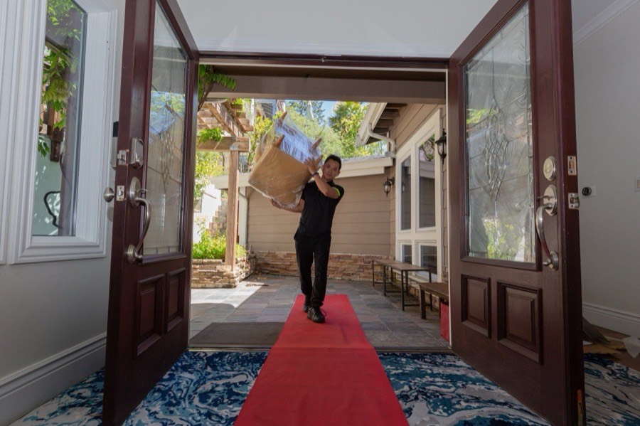 A mover carrying boxes into a home